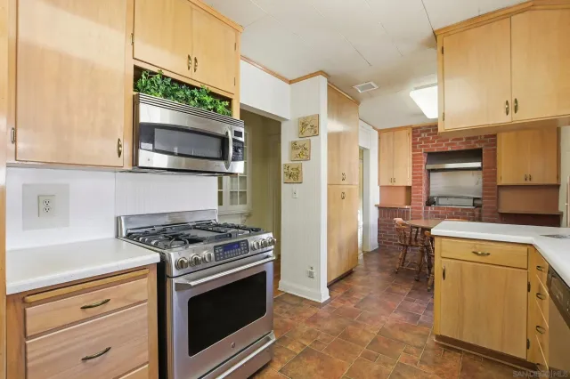 a kitchen with stainless steel appliances granite countertop a stove microwave and refrigerator