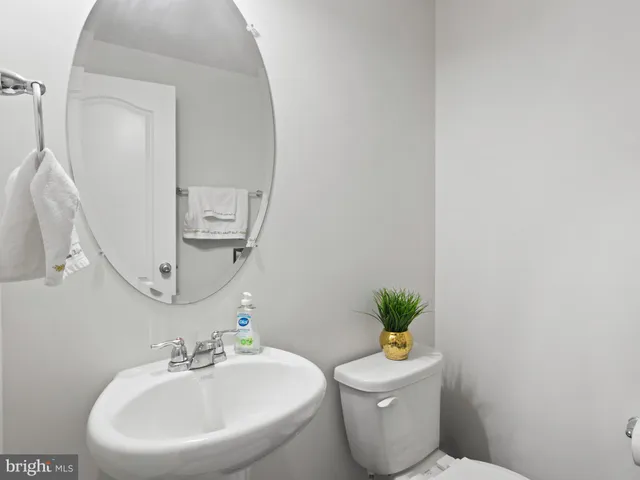 a bathroom with a toilet a sink and mirror