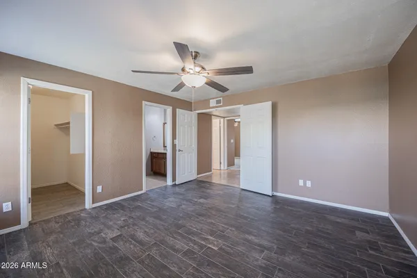 a view of a big room with wooden floor and a ceiling fan