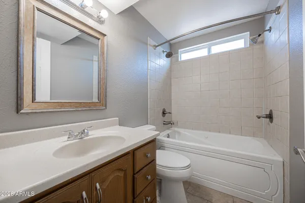a bathroom with a granite countertop sink a toilet and shower