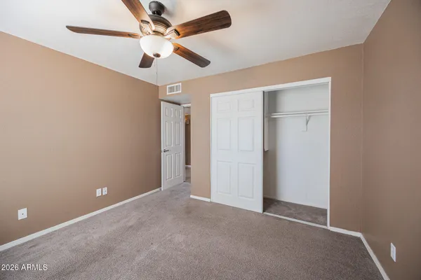 an empty room and chandelier fan