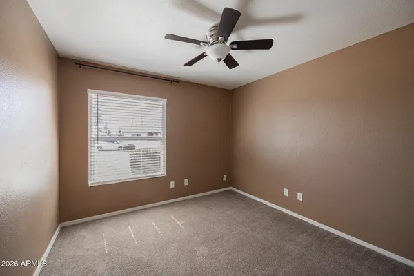 an empty room with a window and a ceiling fan