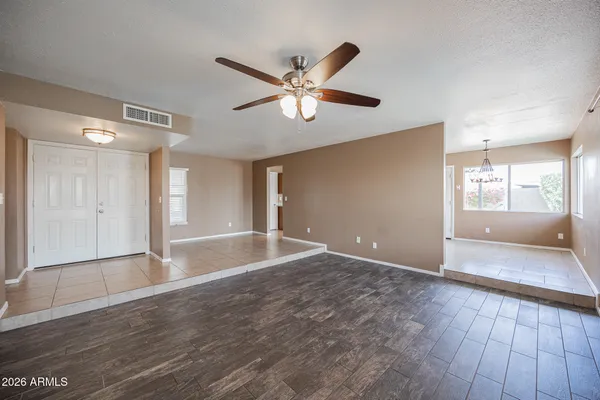a view of an empty room with window and wooden floor