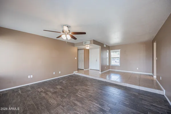 a view of an empty room with window and wooden floor