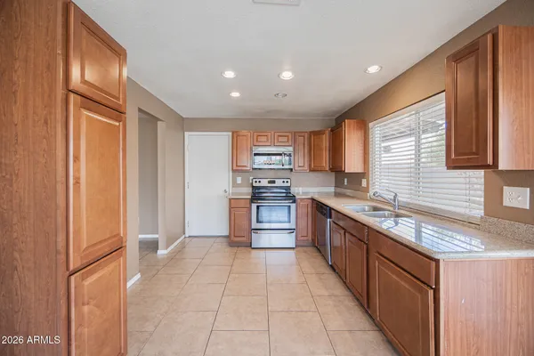 a large kitchen with stainless steel appliances granite countertop a refrigerator and a sink