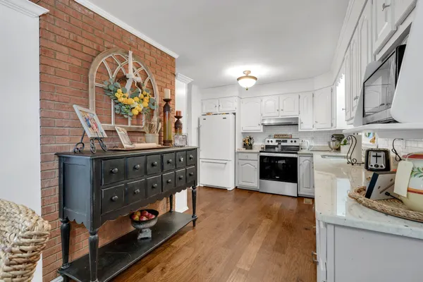 a kitchen with granite countertop white cabinets and white appliances