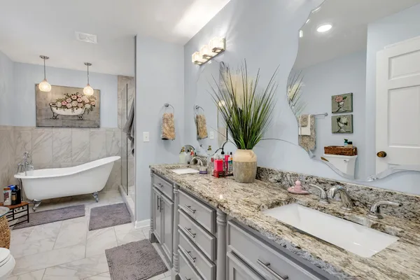 a bathroom with a tub a toilet and a shower