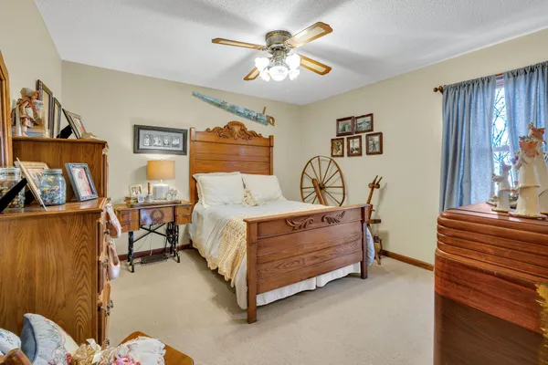 a bedroom with a bed dresser and wooden floor