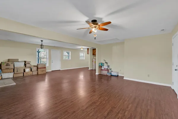 an empty room with wooden floor and window