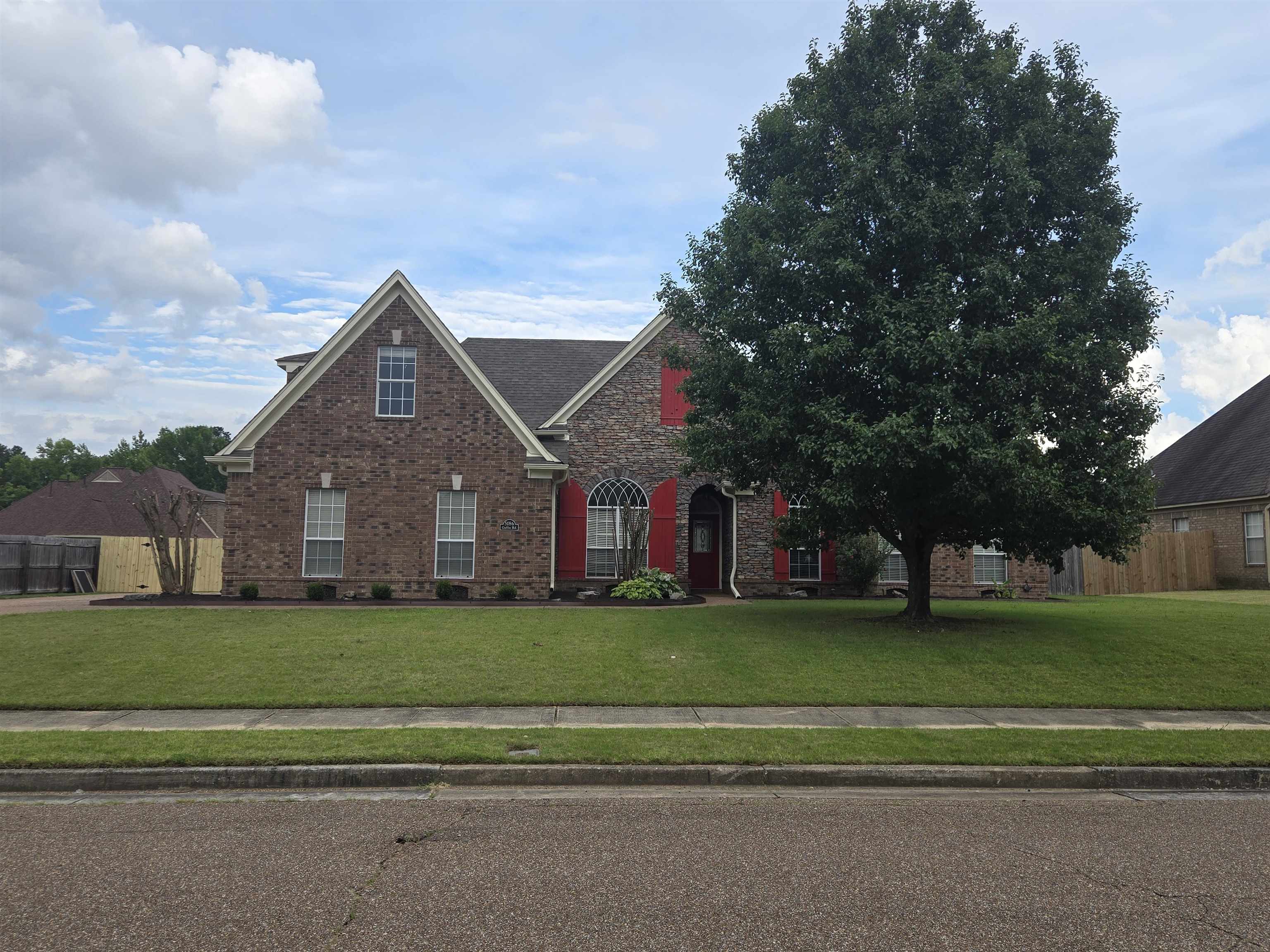 Traditional-style house with a front yard and brick siding