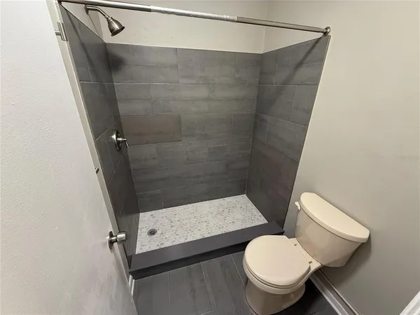 a bathroom with a toilet and a shower