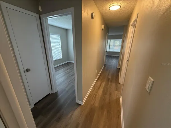 a view of a hallway with wooden floor and staircase