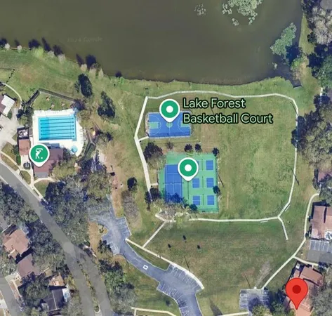 a view of a balcony with wooden floor and a large tree