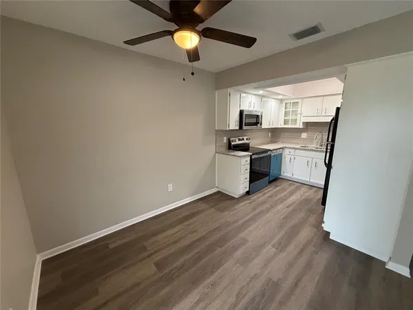 a kitchen with a wooden floor and white appliances