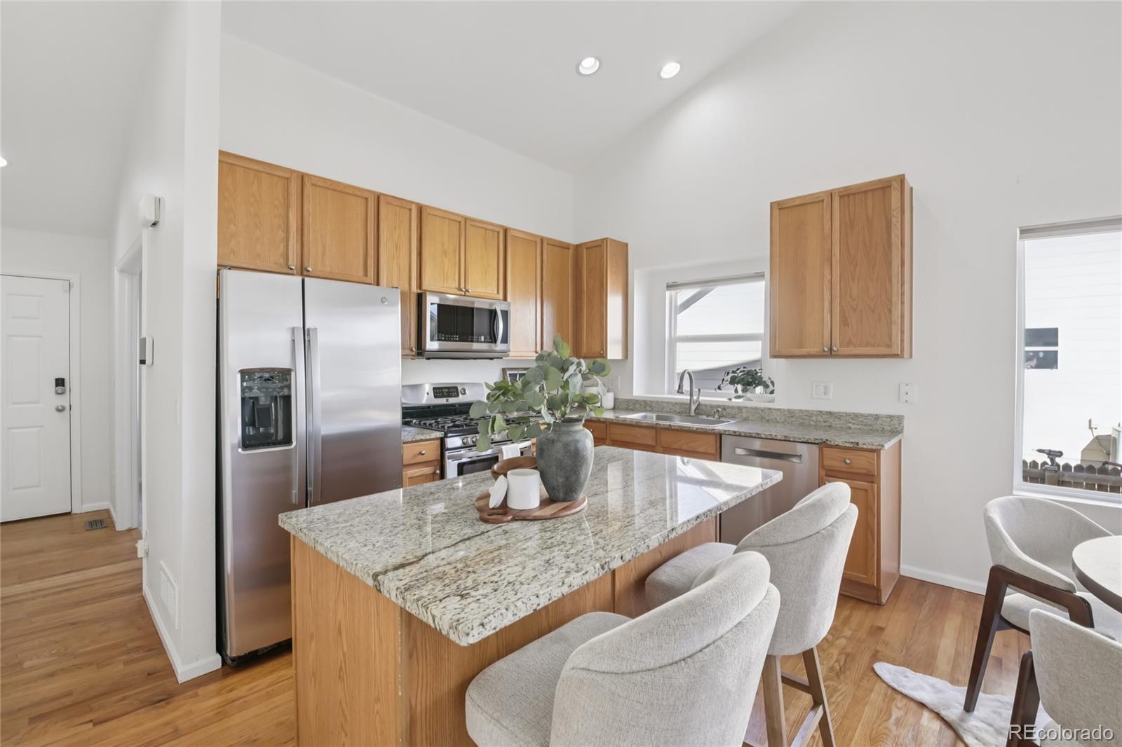 11340 Locust Street Thornton, CO 80233 - Photo 2 of 33 a kitchen with stainless steel appliances granite countertop a sink refrigerator and cabinets