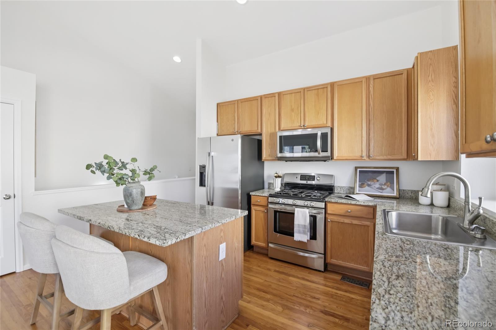 11340 Locust Street Thornton, CO 80233 - Photo 5 of 33 a kitchen with granite countertop a sink stove and refrigerator