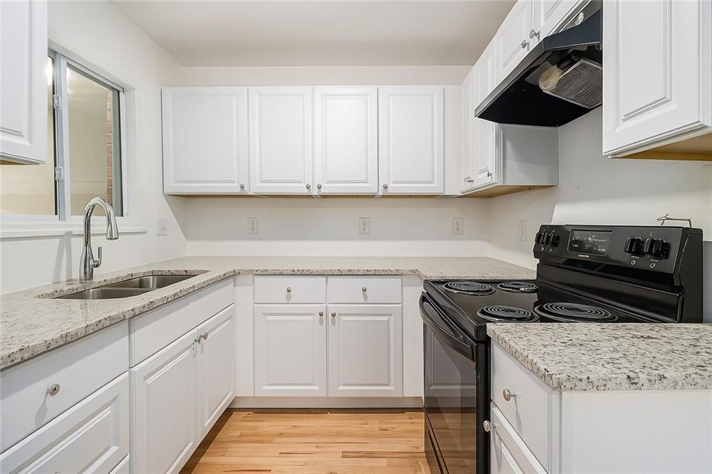 2115 Nichols Lane Decatur, GA 30032 - Photo 7 of 21 a kitchen with granite countertop a sink stainless steel appliances and white cabinets