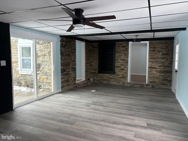 a view of a room with wooden floor and a ceiling fan