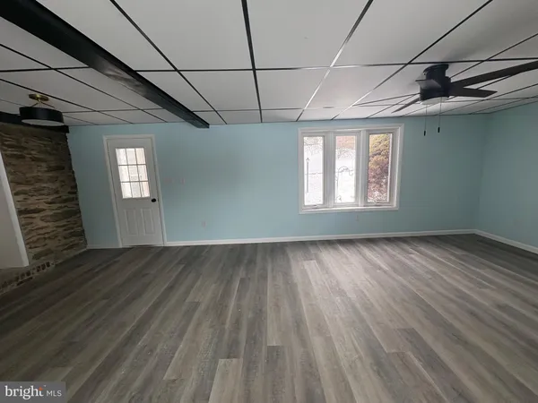 a view of empty room with window and wooden floor