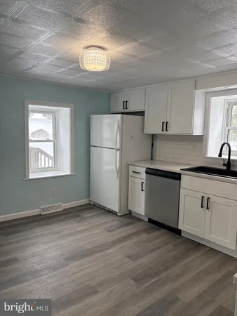 a kitchen with granite countertop a refrigerator and a stove top oven