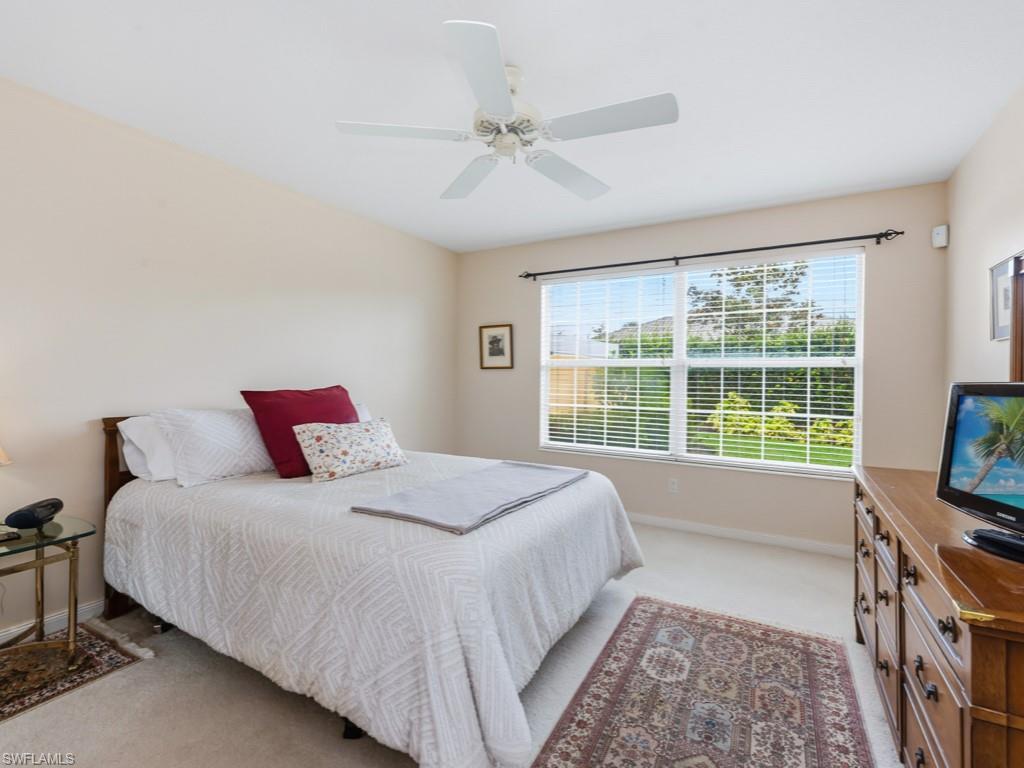 7520 Firenze Lane Naples, FL 34114 - Photo 13 of 32 a spacious bedroom with a bed and a flat tv screen on the dresser