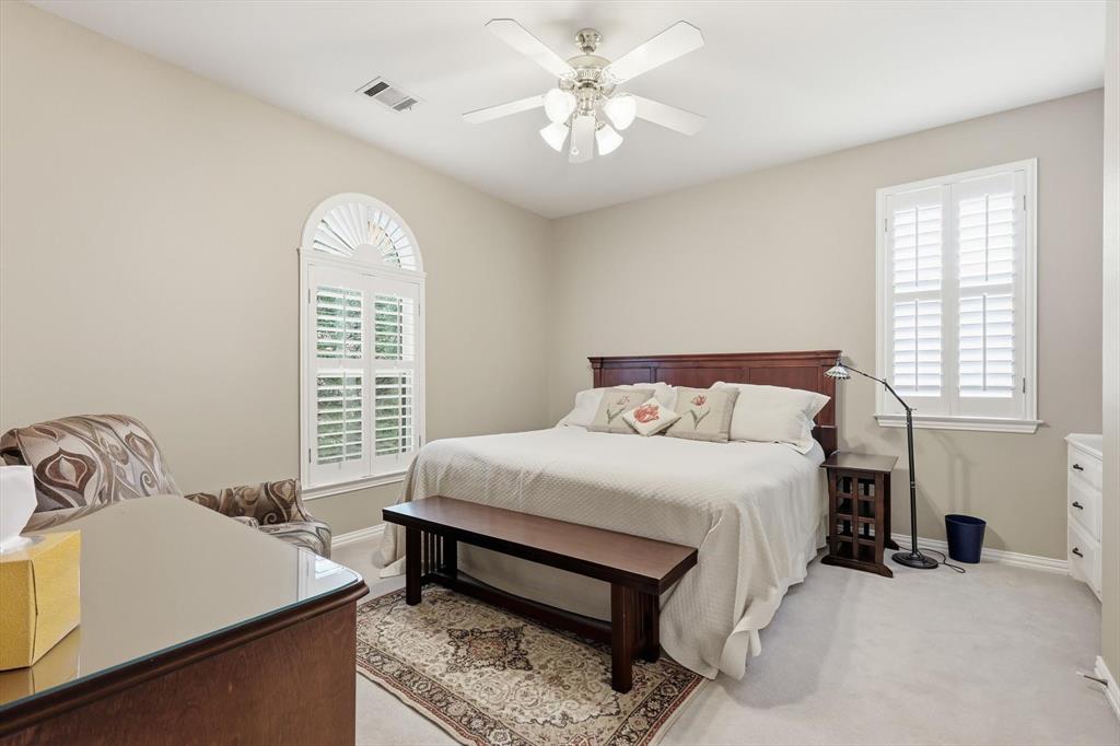 3413 Lantz Circle Plano, TX 75025 - Photo 18 of 38 a bedroom with a bed and a chandelier