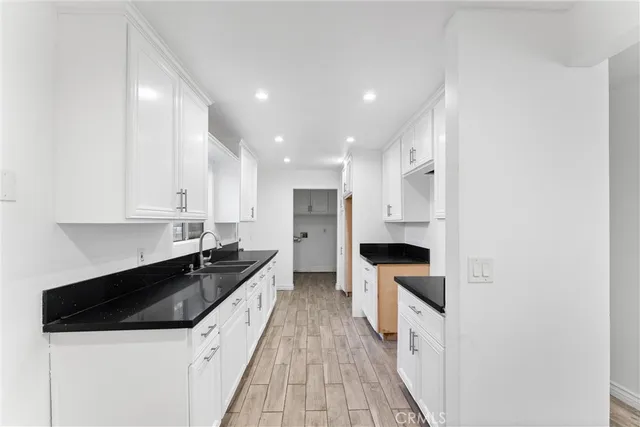 a large kitchen with a sink and white cabinets