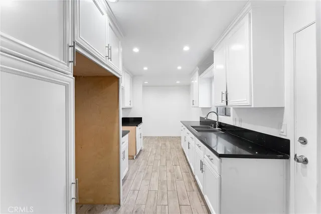 a kitchen with granite countertop a sink and wooden cabinets