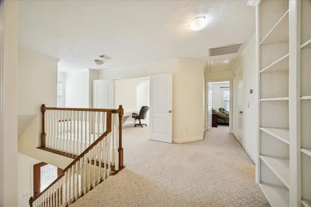 a view of a hallway with wooden floor and stairs