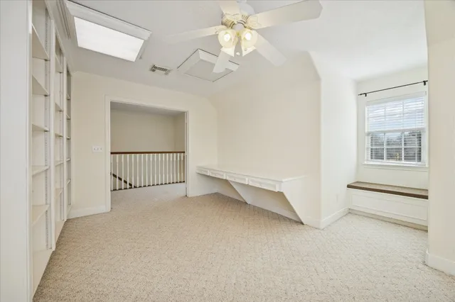 en empty room with windows and ceiling fan