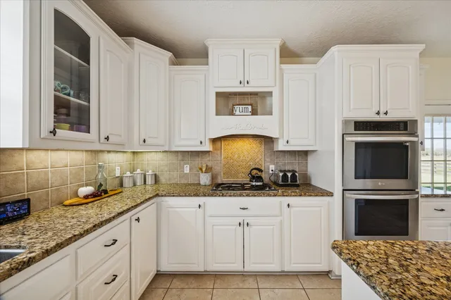 a kitchen with stainless steel appliances granite countertop a sink stove and cabinets
