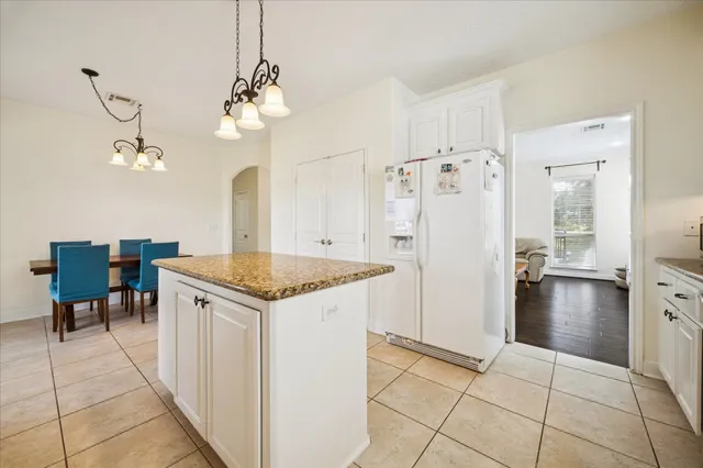 a kitchen with a stove a refrigerator and a dining table