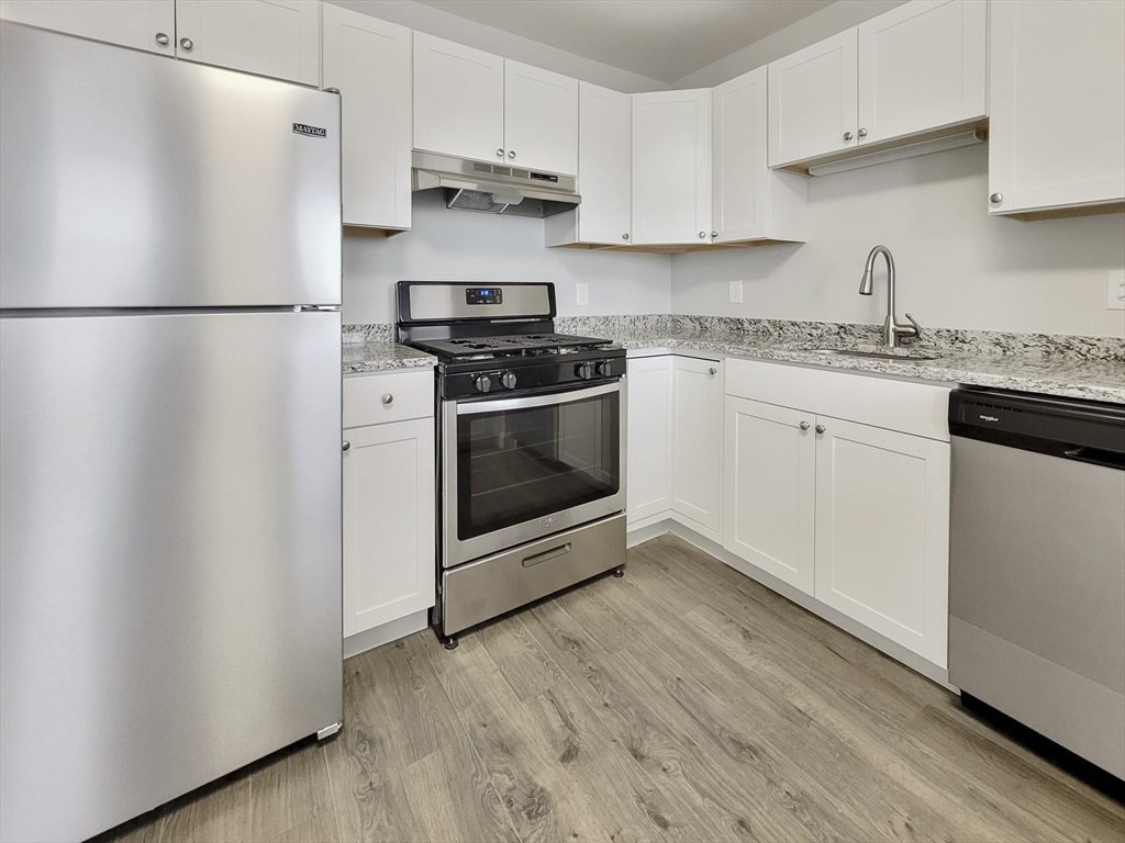 a kitchen with stainless steel appliances a refrigerator sink and cabinets