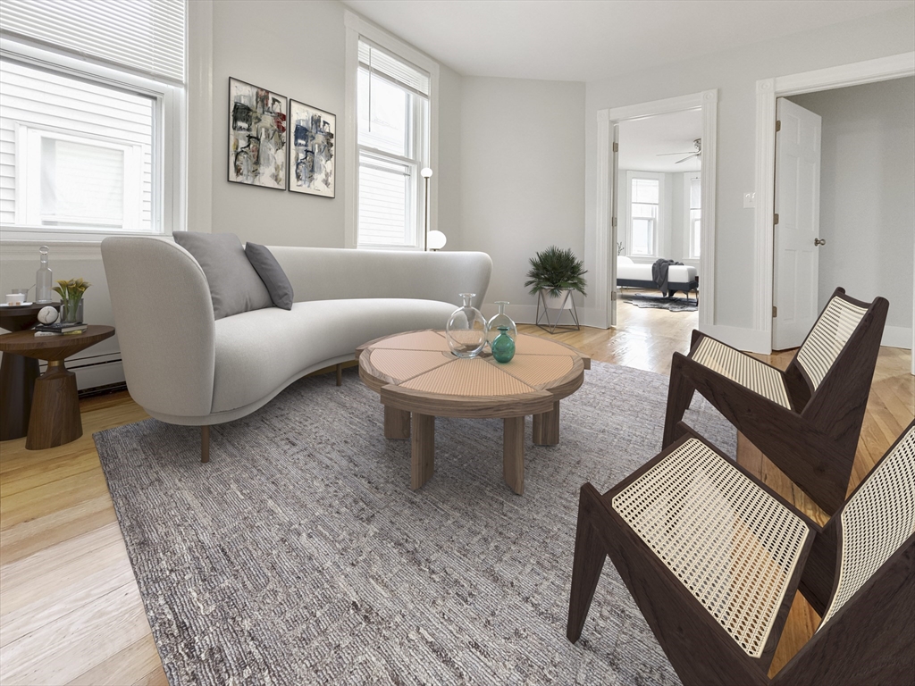 44 Guild Street, Unit 2 Boston, MA 02119 - Photo 4 of 8 a living room with furniture a wooden floor and a window