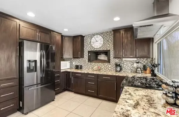 a kitchen with stainless steel appliances granite countertop a refrigerator and a stove