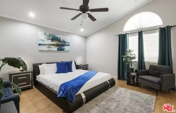 a bedroom with a bed a couch and a chandelier