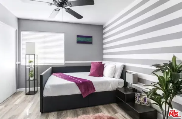 a bedroom with a large bed and a chandelier