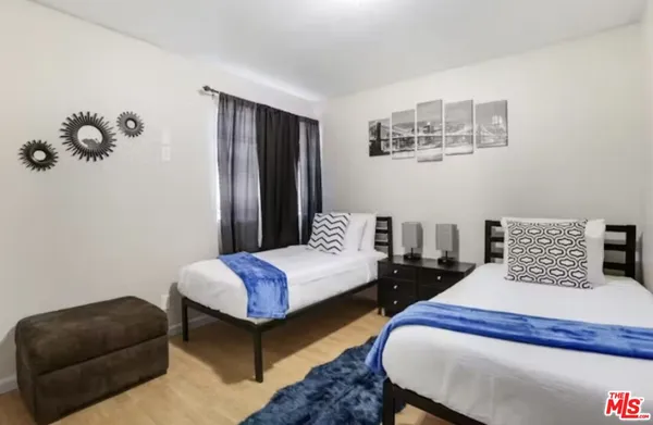 a bedroom with two beds and painting on the wall