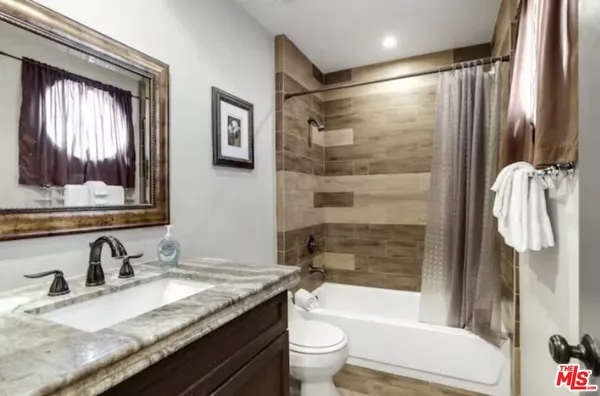 a bathroom with a granite countertop sink toilet and shower