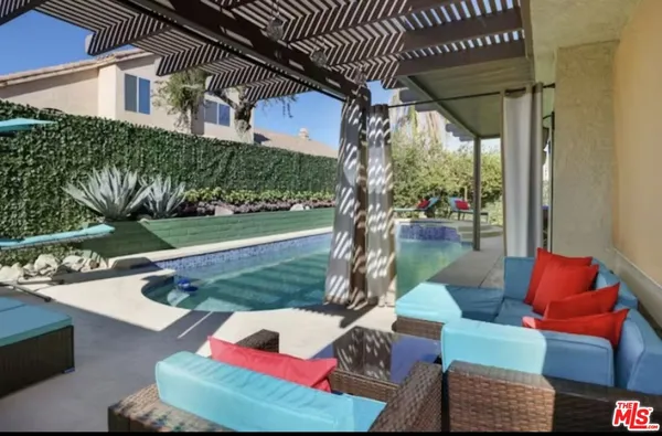 a view of a patio with couches table and chairs and potted plants