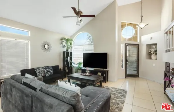 a living room with furniture a large window and a flat screen tv