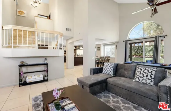 a living room with furniture a fireplace and a chandelier