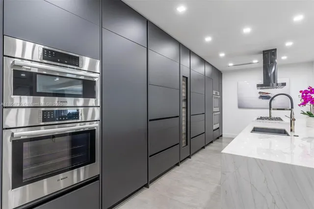 a kitchen with stainless steel appliances kitchen island granite countertop a stove microwave and a sink