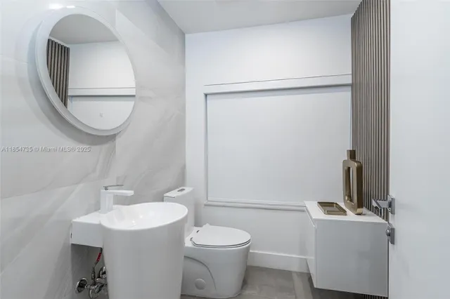 a bathroom with a sink toilet and a mirror