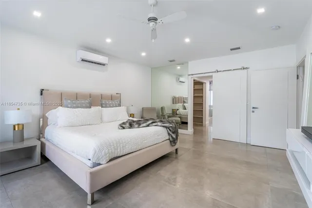 a large bedroom with a bed and a chandelier