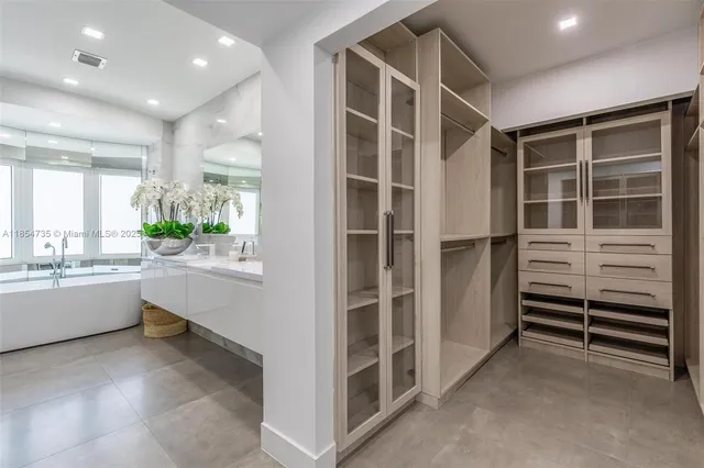 a view of an empty room with a window and cabinet