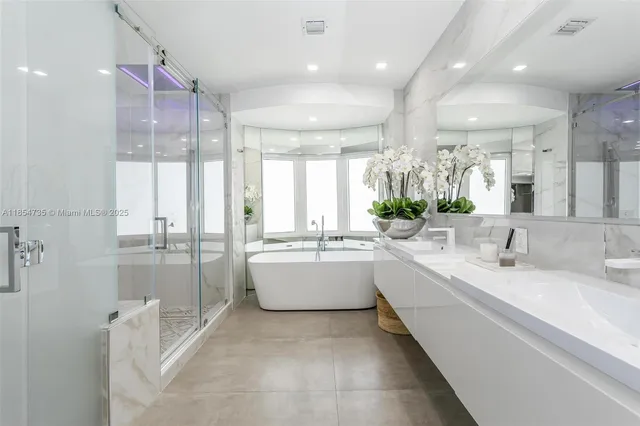 a large white bathroom with a large tub sink and mirror