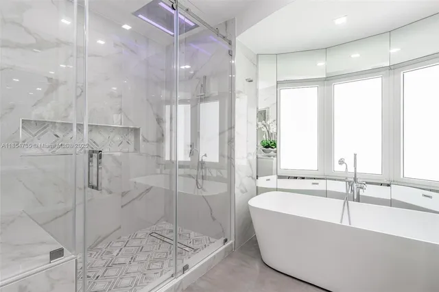 a bathroom with a large tub a sink and shower