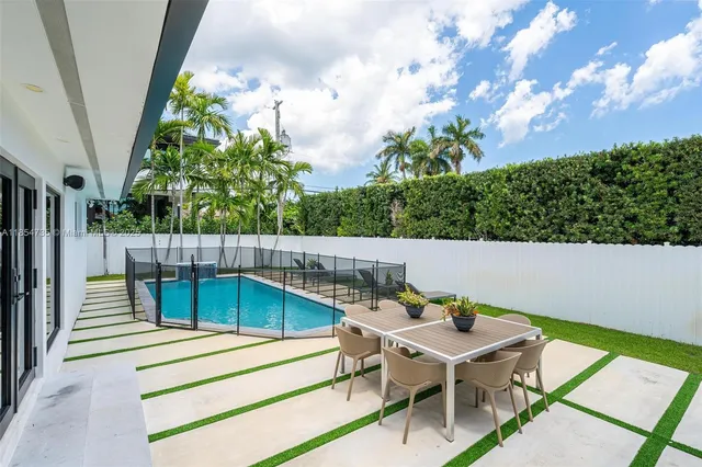 a roof deck with table and chairs and potted plants