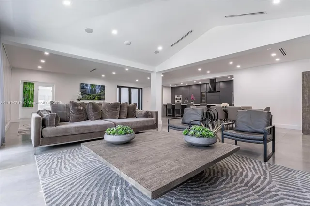 a living room with furniture and view of kitchen